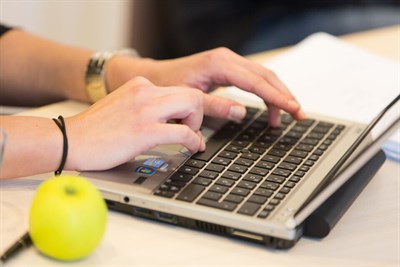 Händer som skriver på ett tangentbord till en dator